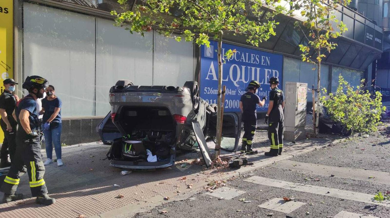 Aparatoso accidente en la calle María de Molina al volcar un coche tras chocar contra una moto y una farola