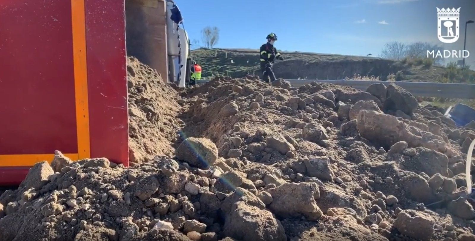 Vuelca un camión cargado de arena en una rotonda de Vallecas y el chófer resulta herido leve