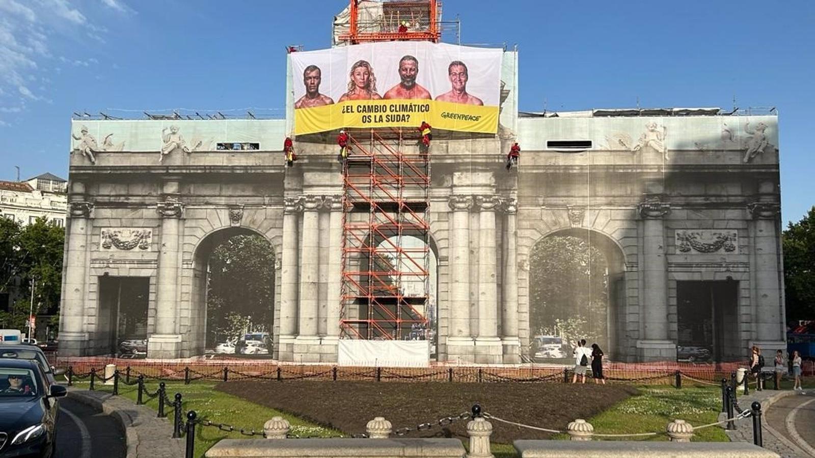 Greenpeace cuelga una lona en la Puerta de Alcalá contra los candidatos: "¿El cambio climático os la suda?"