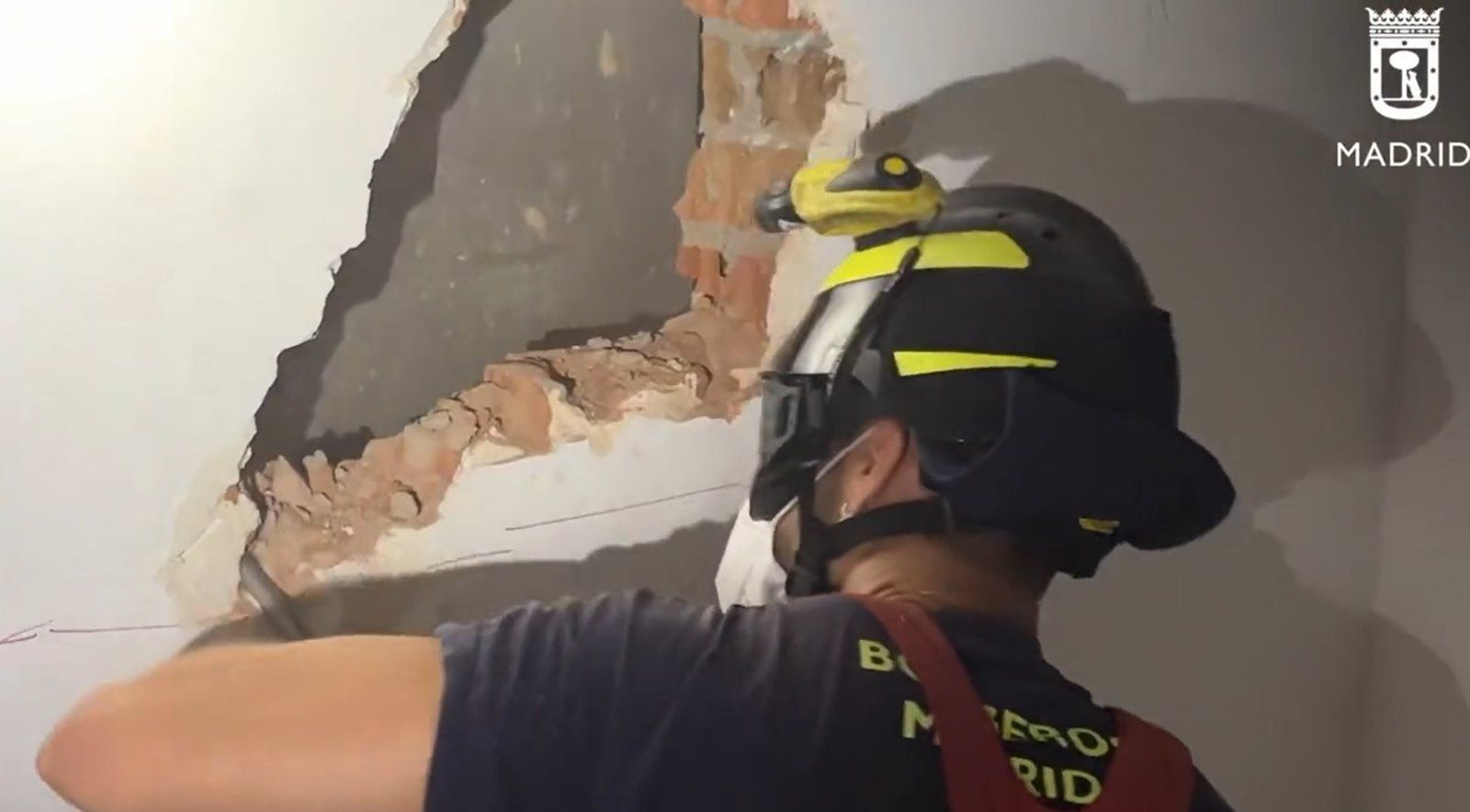 Bomberos de Madrid realizan un butrón en la pared para rescatar a tres personas atrapadas en un ascensor