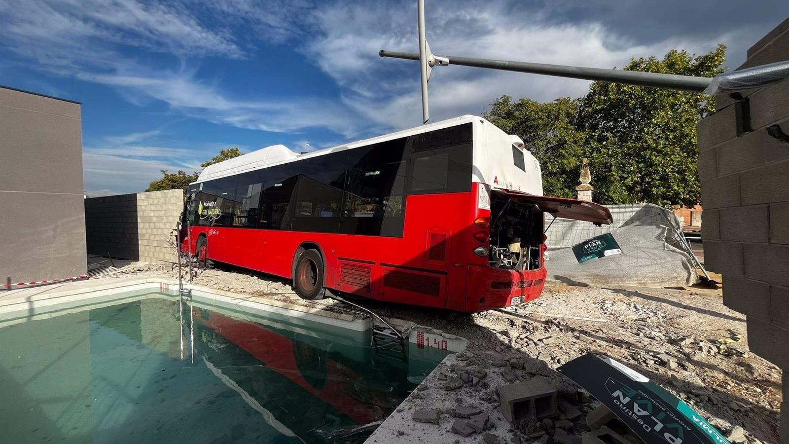 Un autobús sin pasajeros choca contra el muro de un chalé en construcción en Alcalá