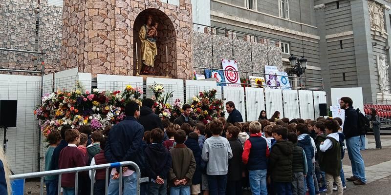 Los niños del colegio El Prado realizan una ofrenda floral a la Virgen de la Almudena